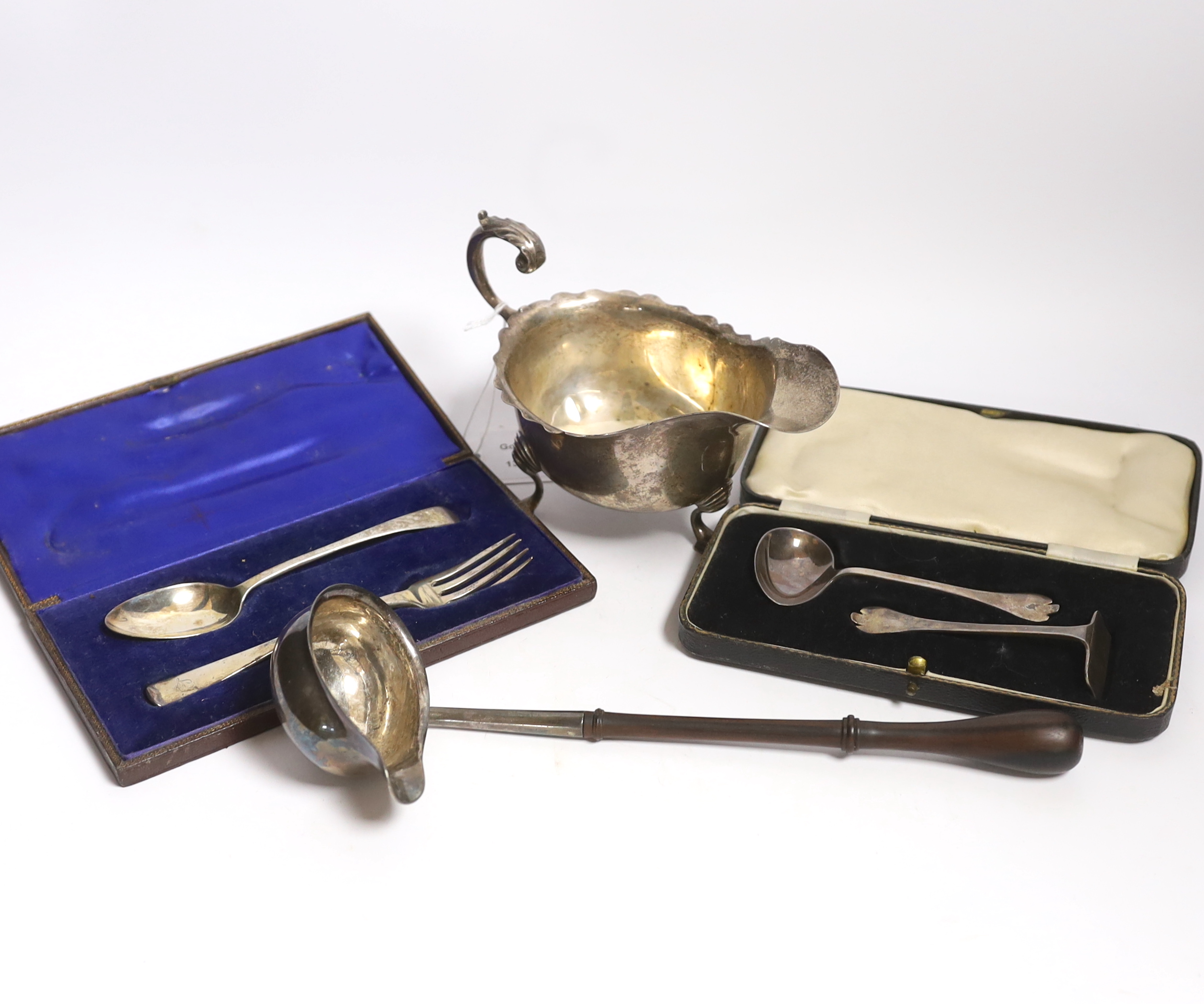 A small group of silver items to include a George V sauceboat, London, 1934, a George III toddy ladle, London, 1766 and later cased christening cutlery, etc.